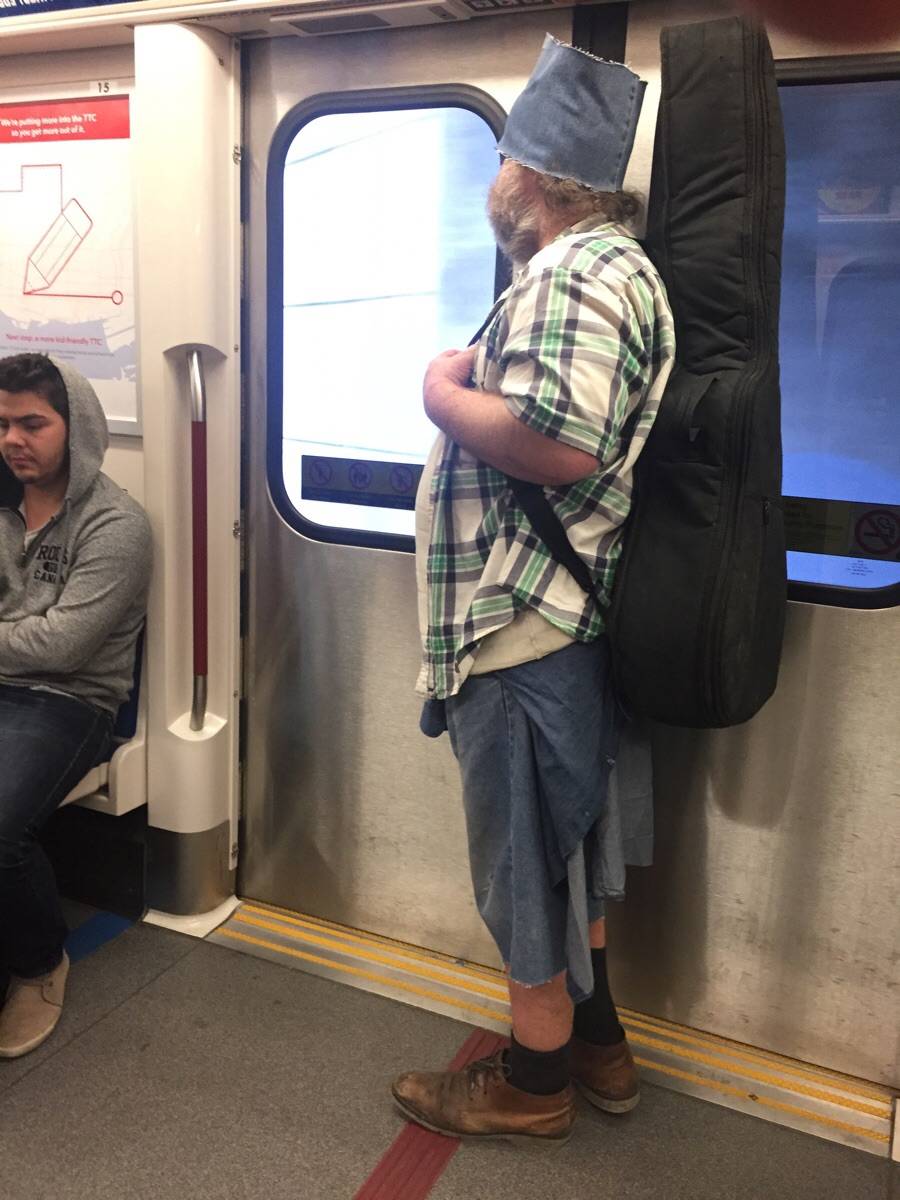 Man on subway wearing cut off piece of jeans as a hat. 