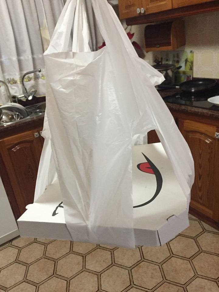Pizza box in a plastic bag with the corners cut out of it. 