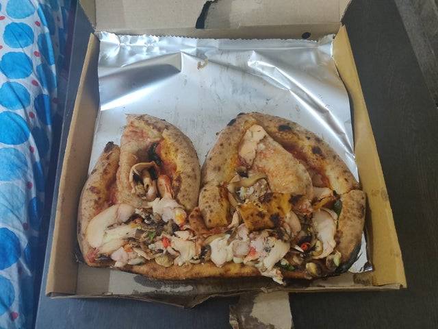 Pizza that is smushed inside a box. 