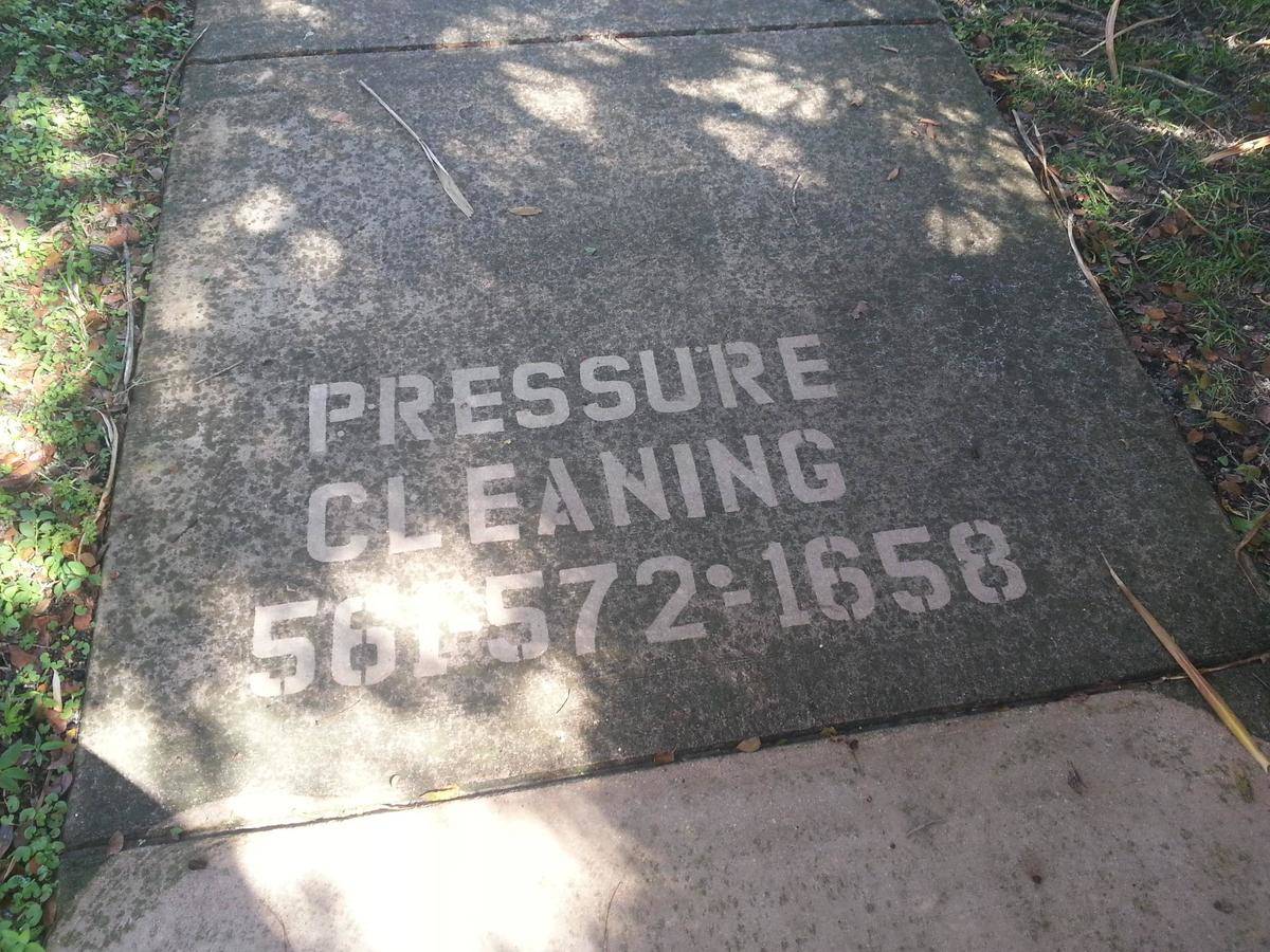 Pressure cleaning service ad on a sidewalk.