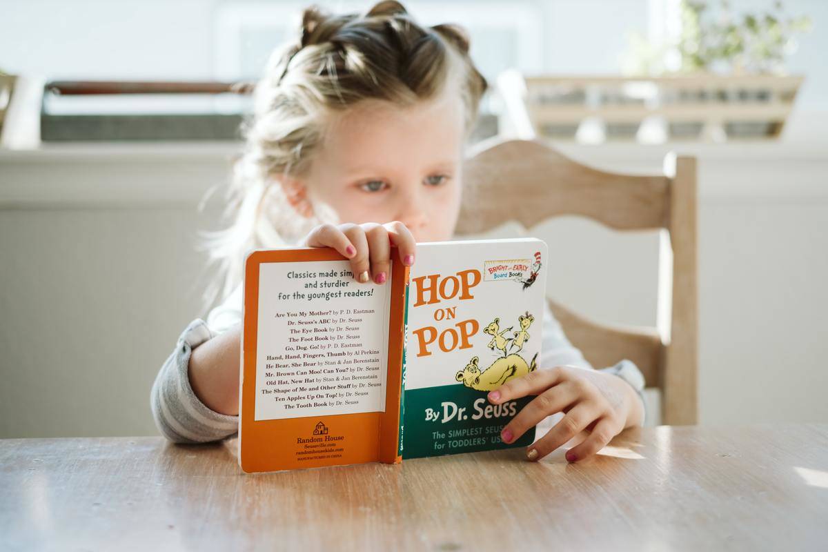 A child reads a book by Dr. Seuss