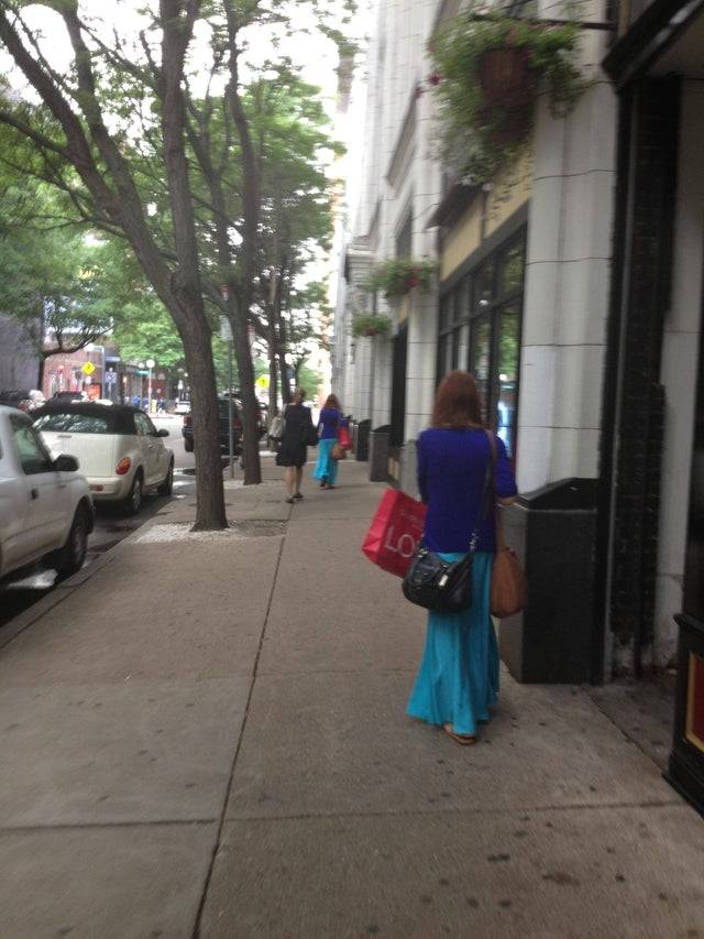 Person on the street who is wearing the same colored clothes as someone else down the street. 