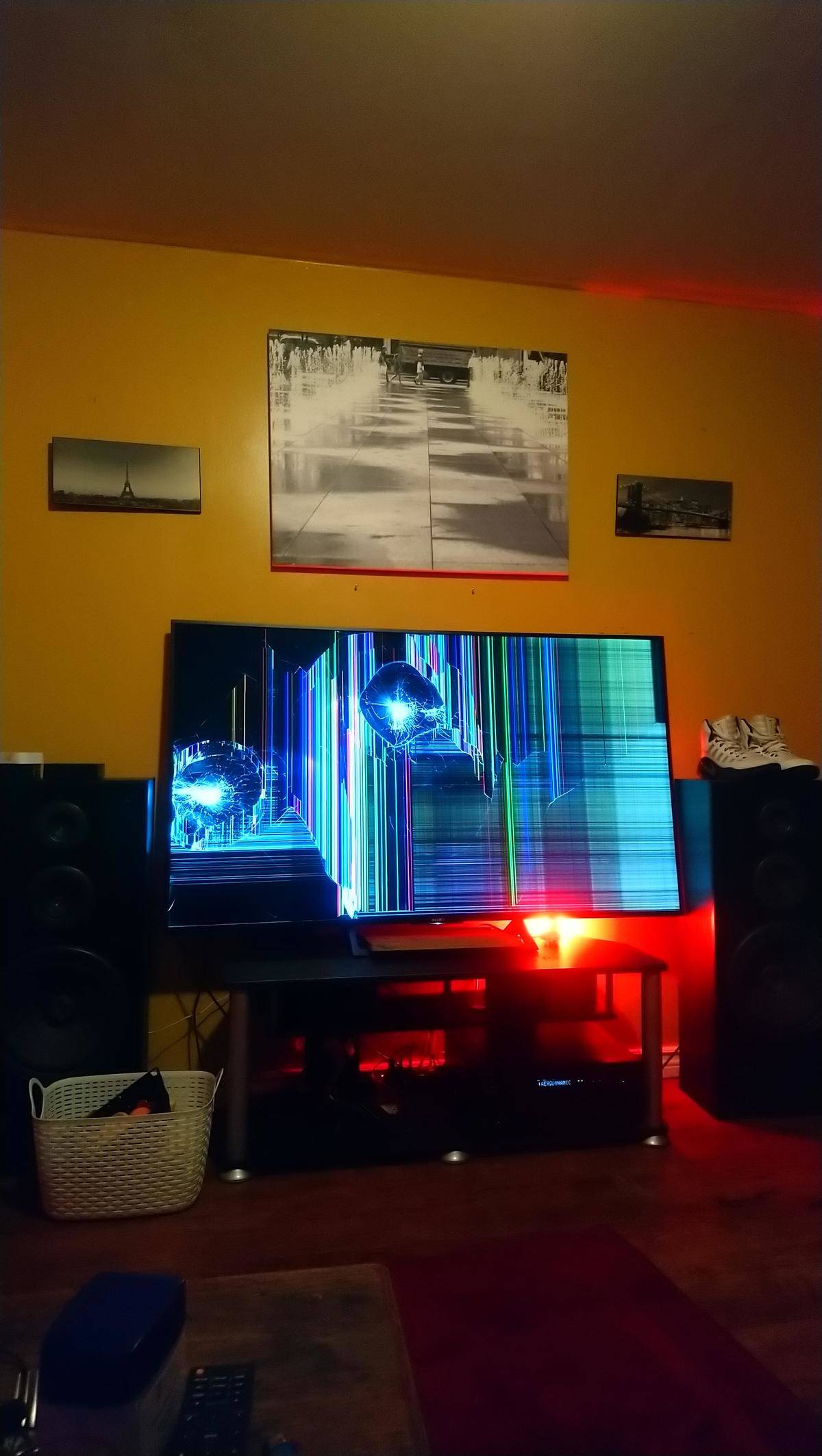 Smashed big flatscreen TV hanging on wall