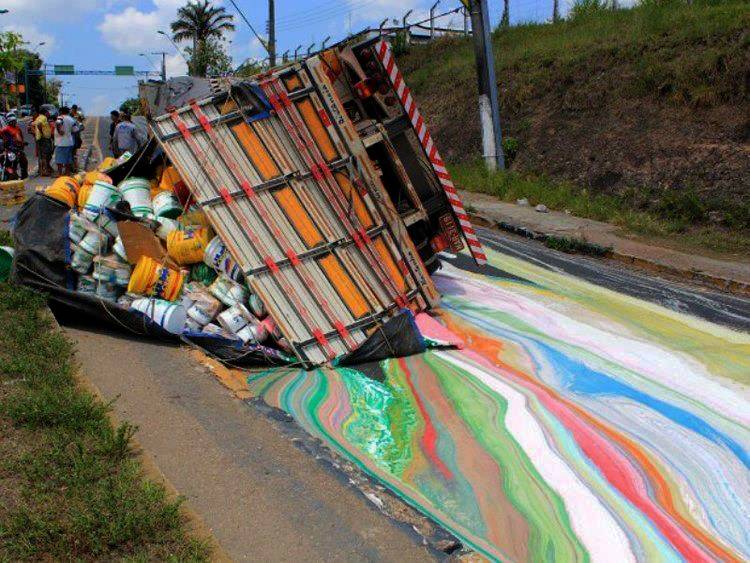 Truck that has fallen over and paint buckets it was transporting have spilled onto the road.