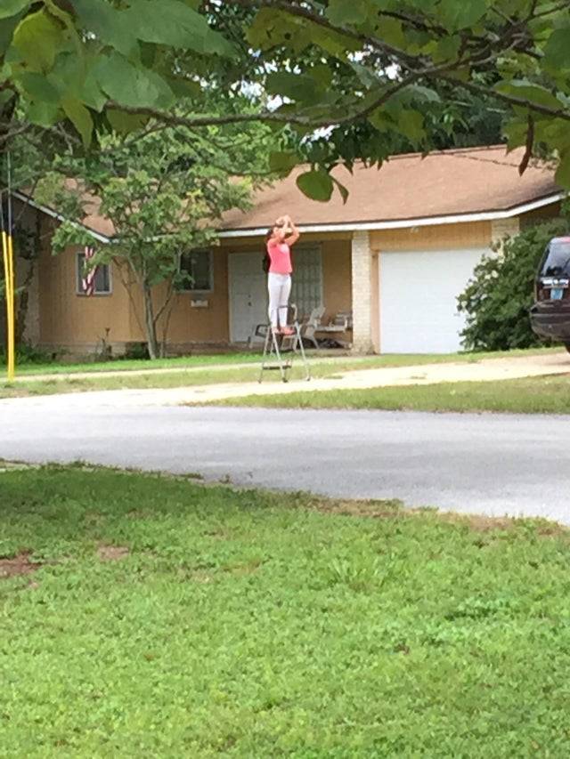 Woman standing on stepping stool to see eclipse bette