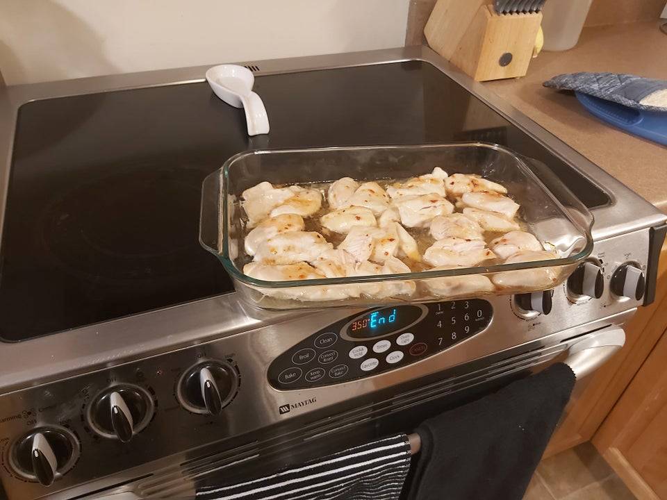 Chicken balanced on edge of kitchen stove