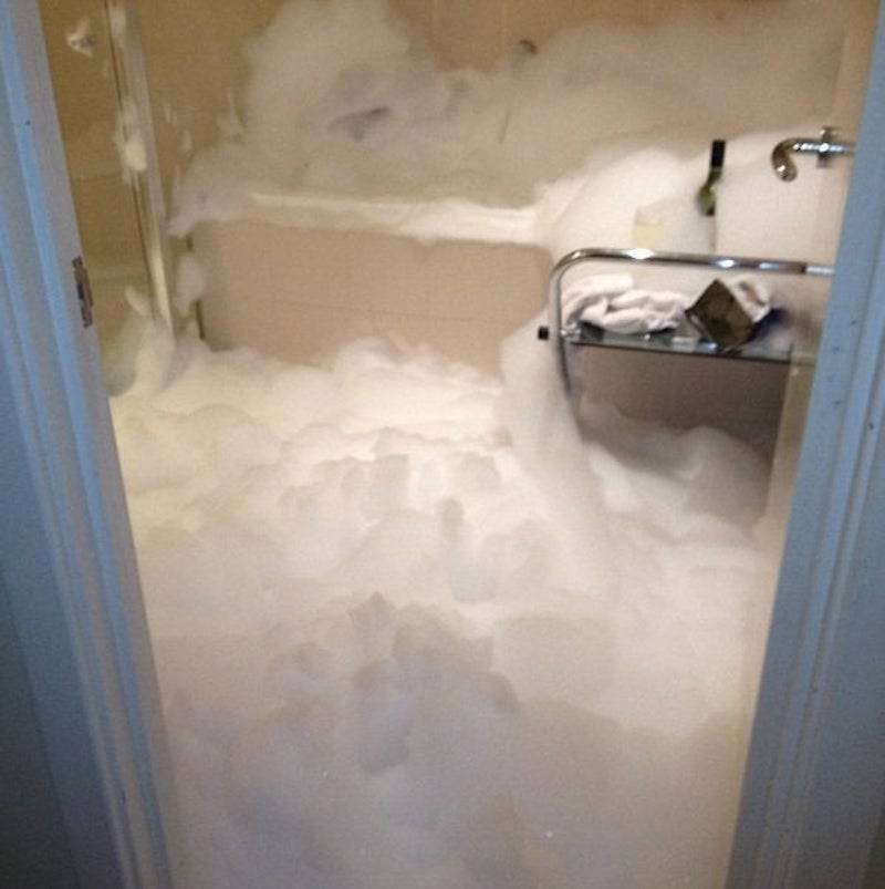 Bathtub overflowing to fill the entire room with soapy bubbles