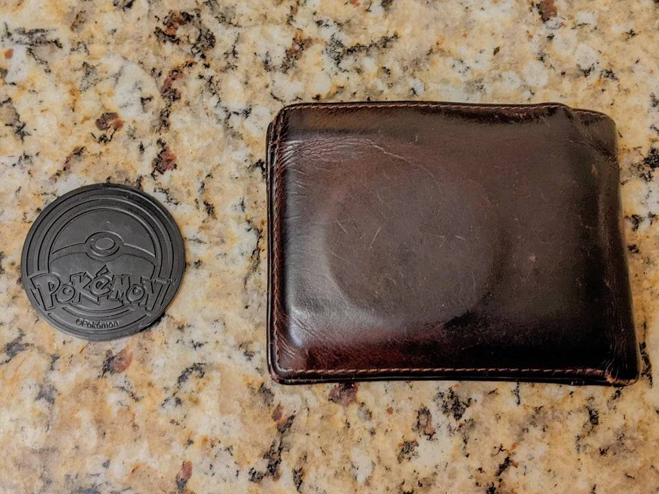 A Pokemon coin inside of a wallet which looks suspiciously like a condom.