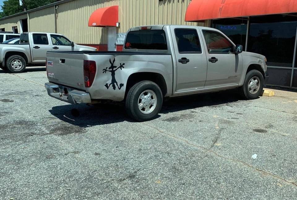 Wile E. Coyote sticker on a dented truck.