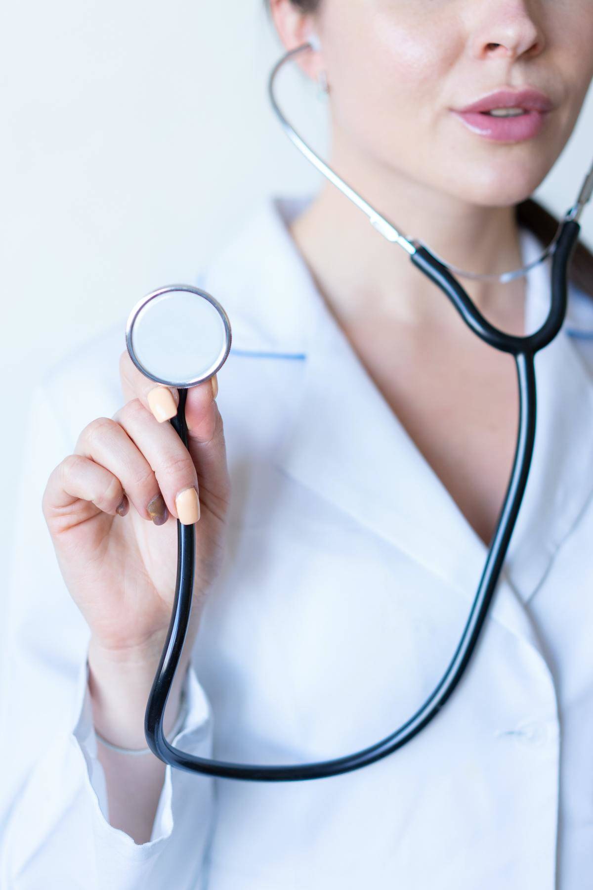 A female doctor holds out a stethoscope