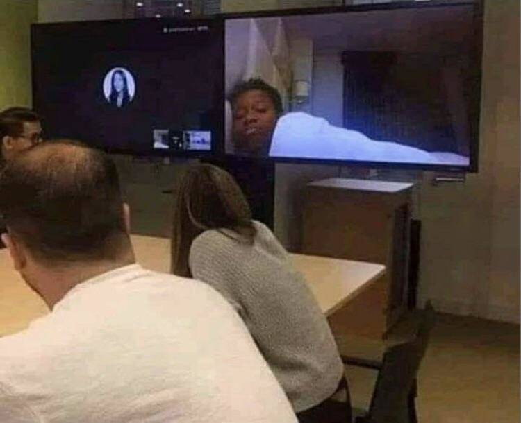 Employee accidentally presses video during a work meeting, showing them still tucked into bed.