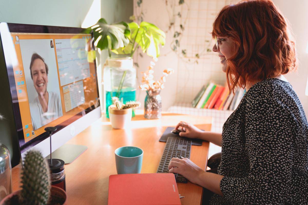 Woman smiling while talking to man on virtual call