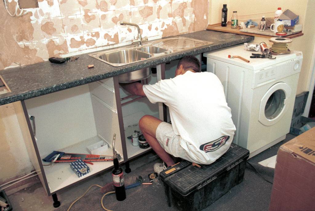 man fixing a sink