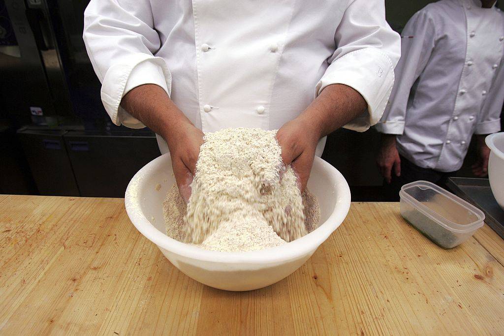 chef mixing a bowl of flour