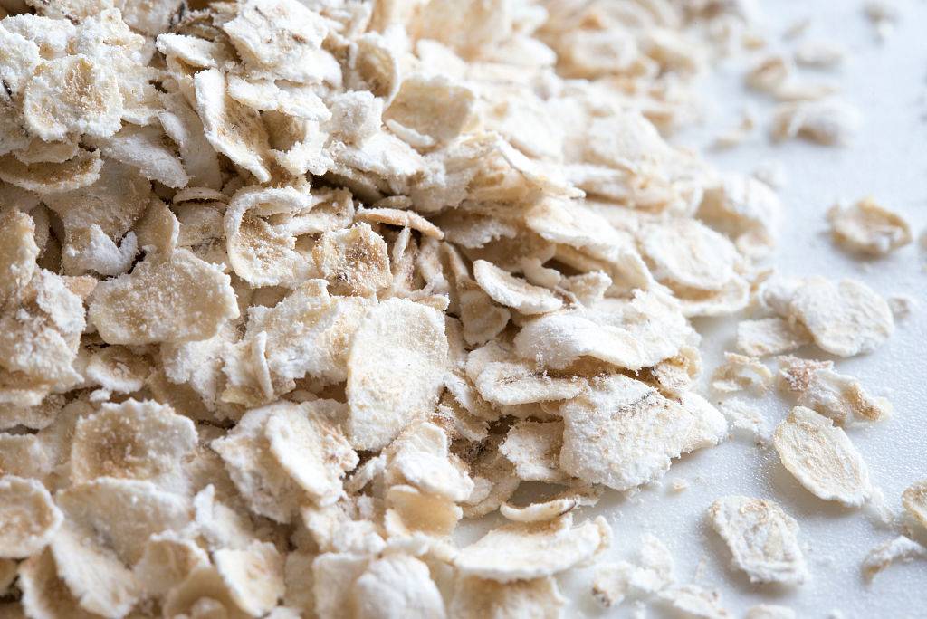 Close-up of white powdery oatmeal flakes on a white surface