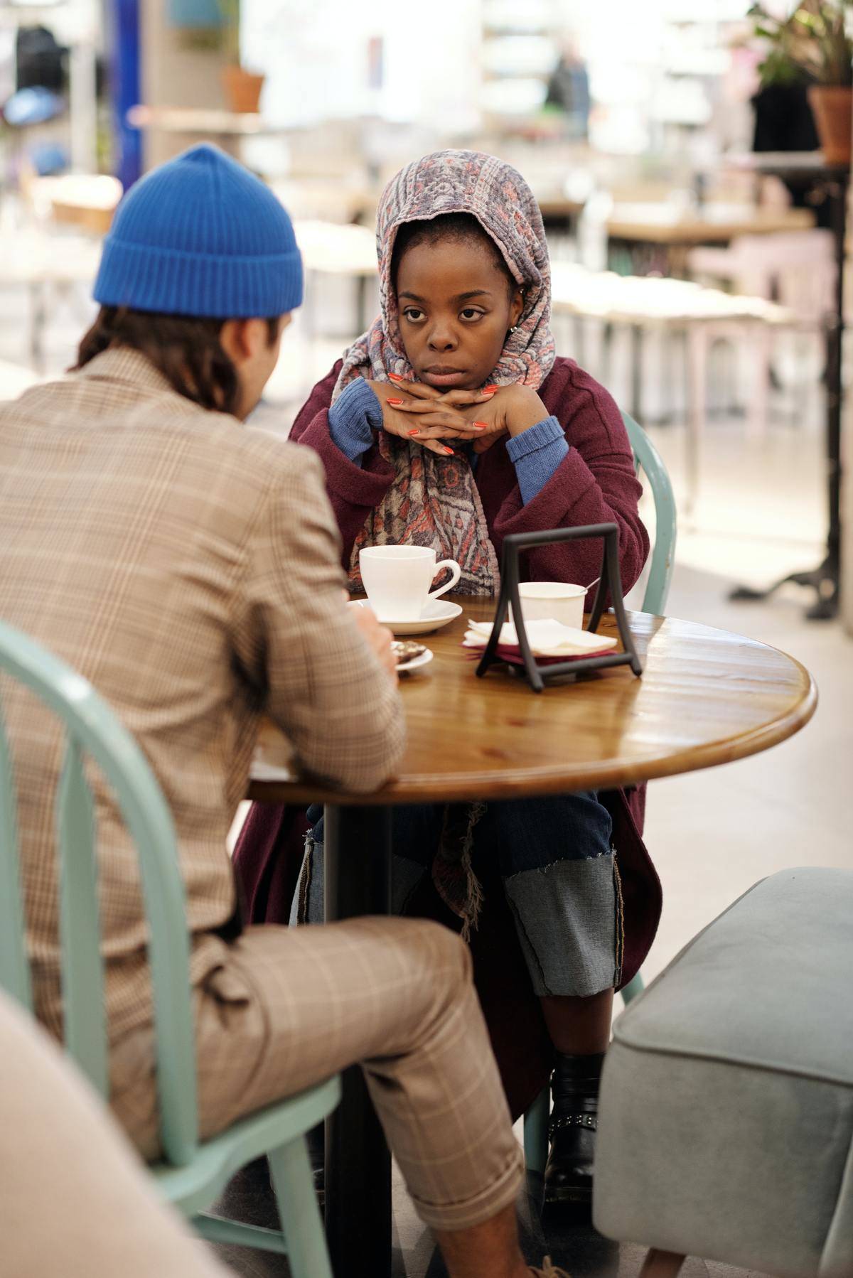 Man and woman at outside bistro table with coffee cups 