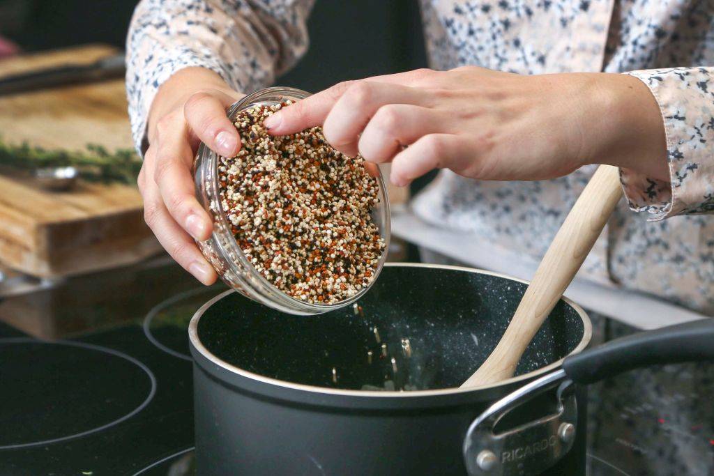 quinoa being poured into a pot