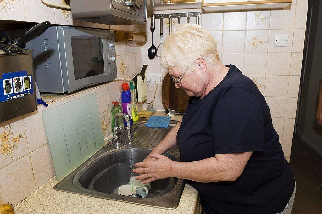 senior woman washing dishes in the kitchen