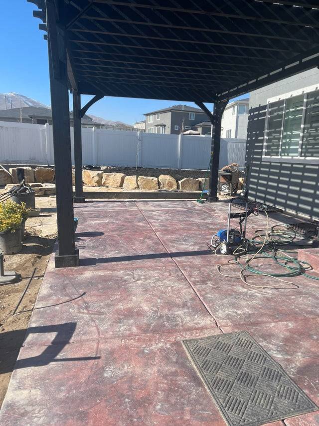 A newly constructed pergola on a backyard patio that doesn't create any shade.