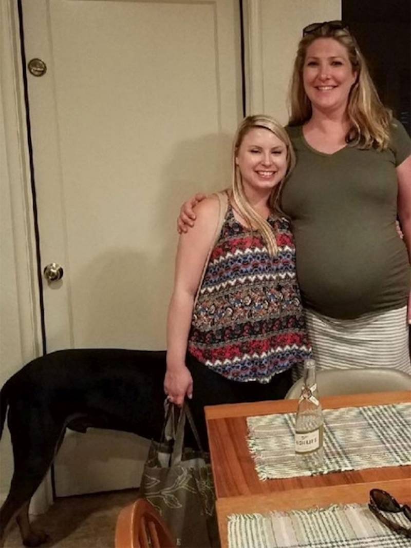 Women pose for photo, dog in back ground makes woman look like centaur in confusing perspective