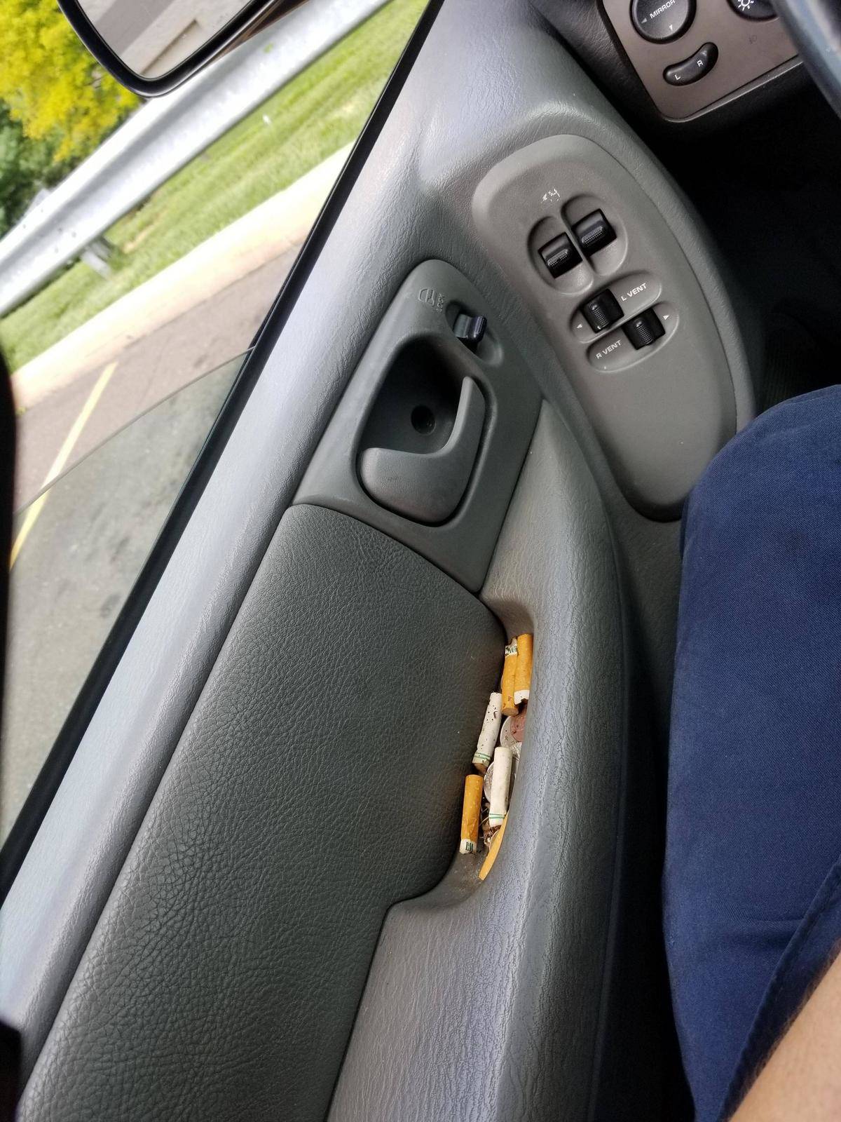 The handle of a car is filled with cigarette butts.