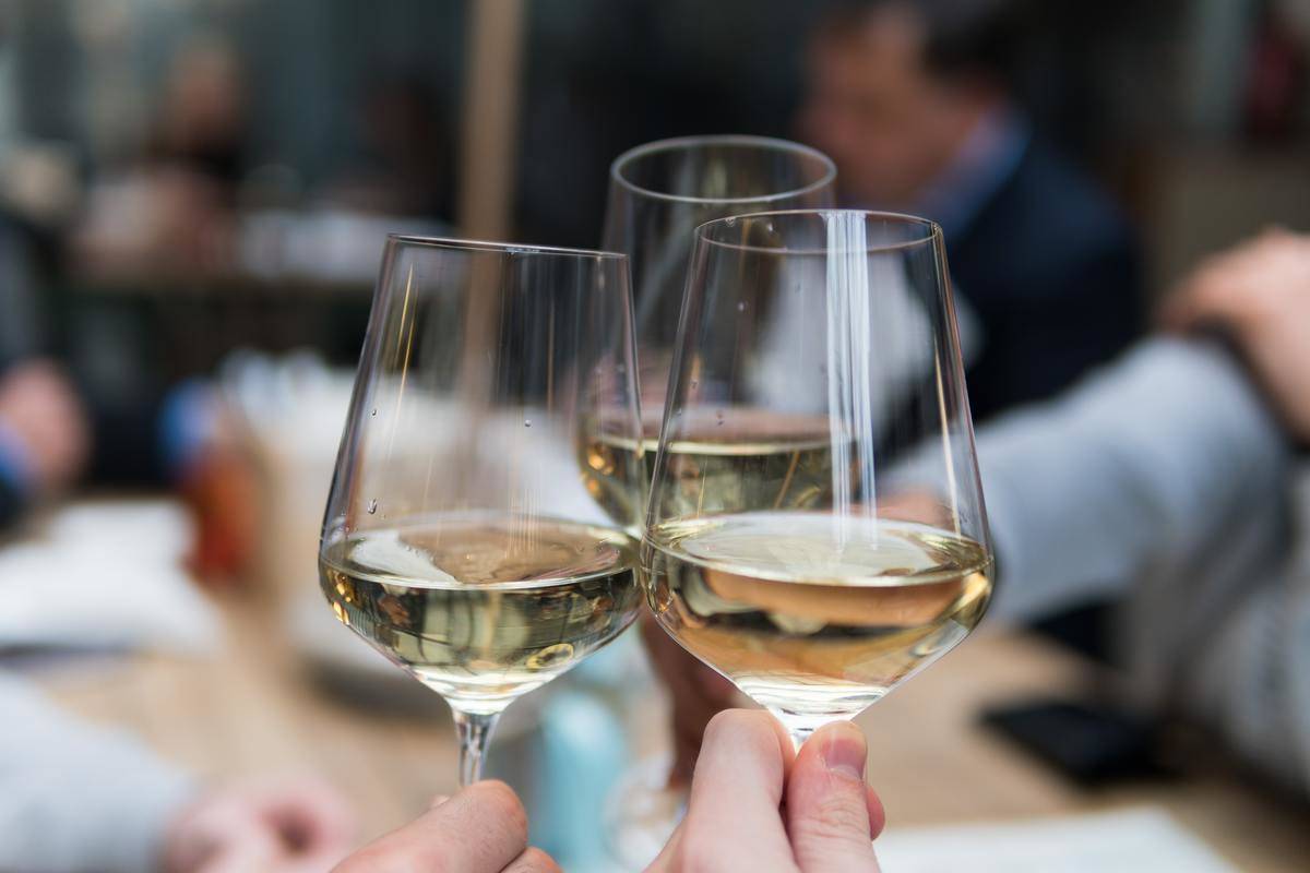 Three glasses cheersing with a drink in them
