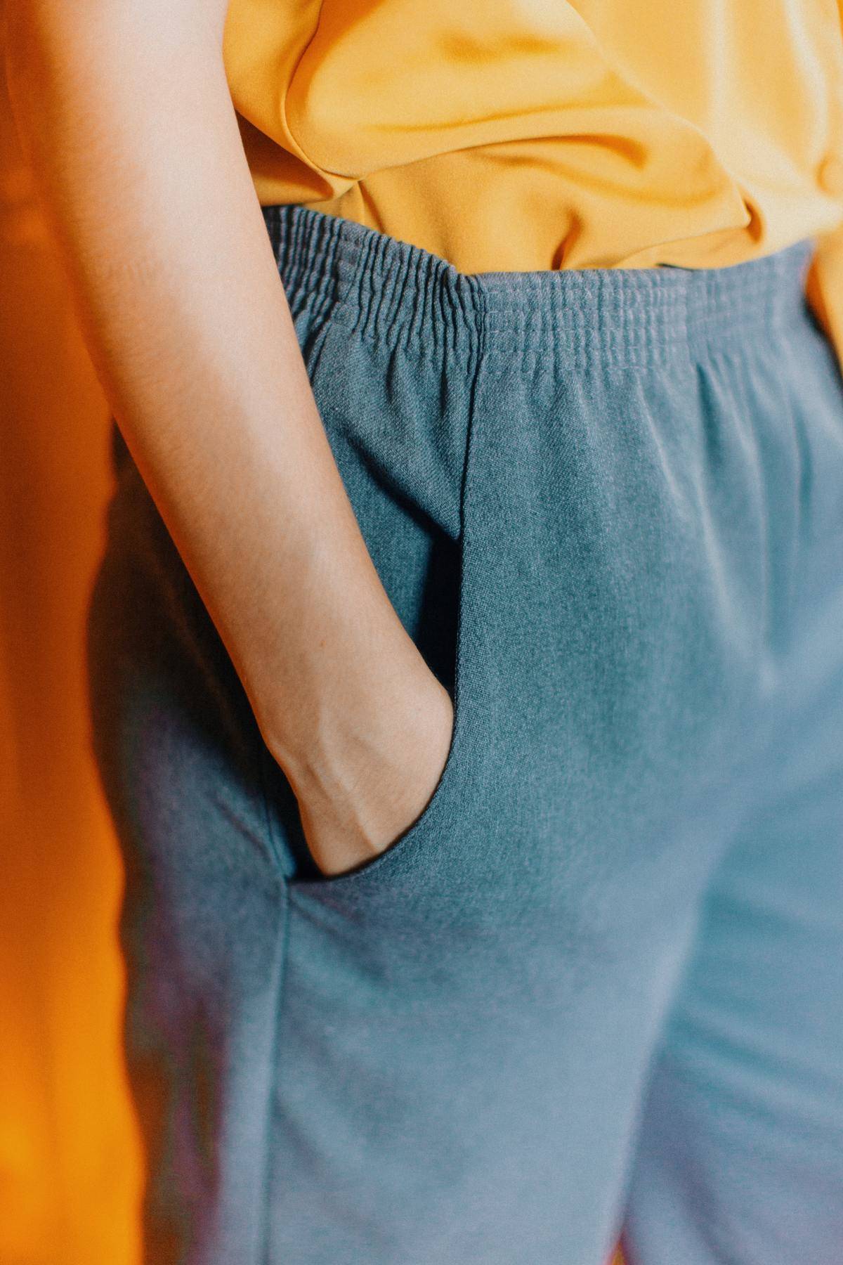 A woman hands her hands in her pants' pocket.