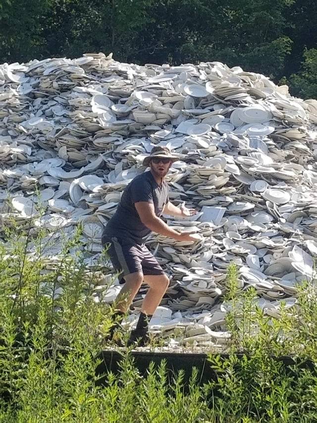 Man standing in front of mountain of dishes