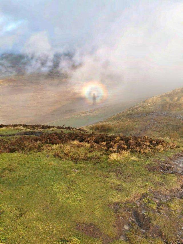circular rainbow ghost over a hill