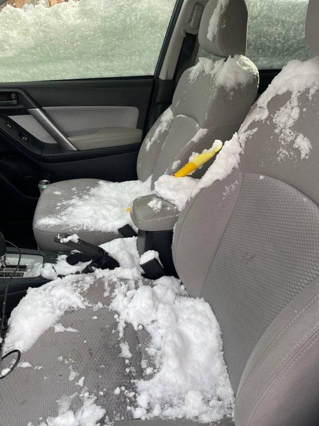 Snow filling front and passenger seats of vehicle