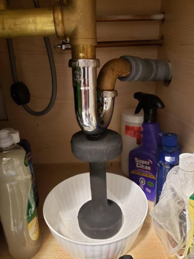 Weight being used to hold up a sink pipe