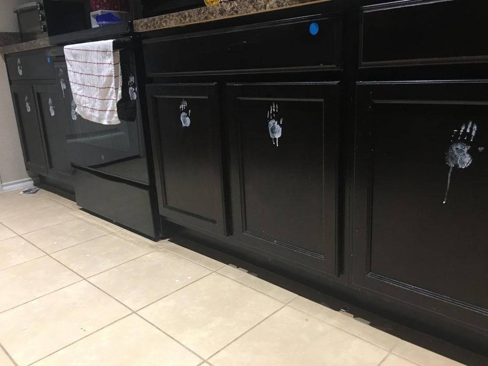 White handprints from toddler on kitchen cabinets