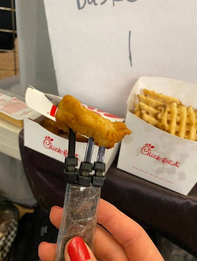 Zip tie used as a fork with a piece of chicken on it.