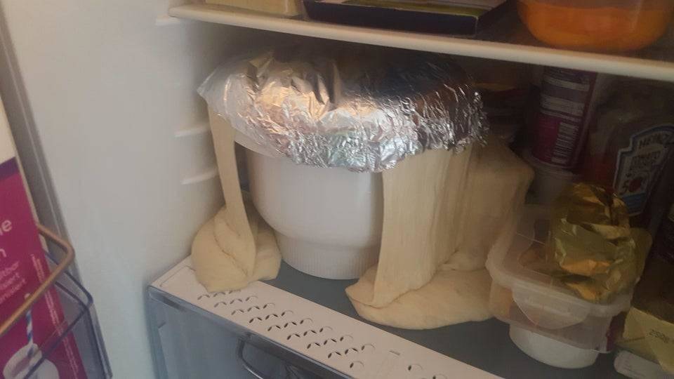 a bowl of dough in a fridge that has overflowed