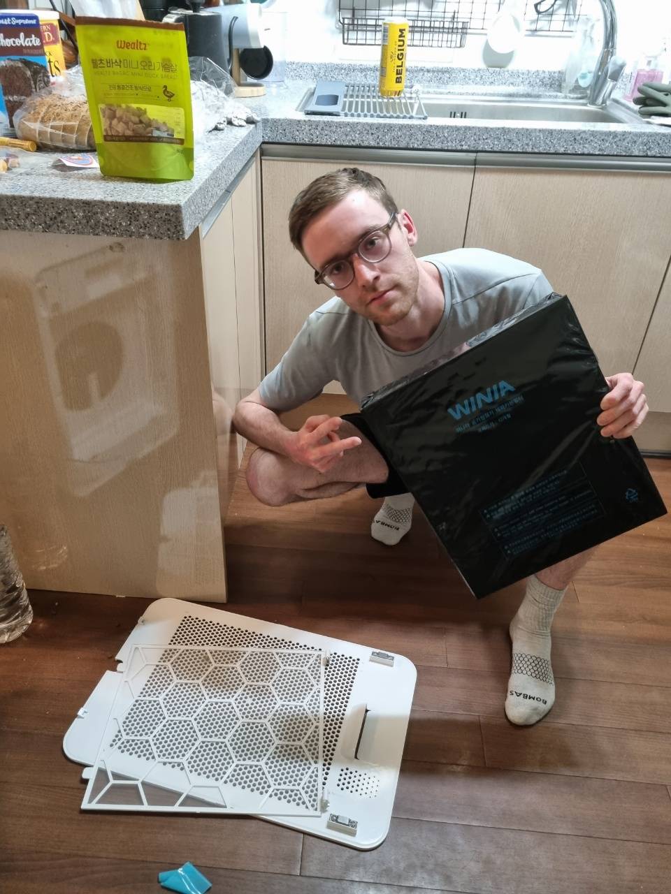 Man poses with his air purifier filter that's had a plastic cover on it the whole time.