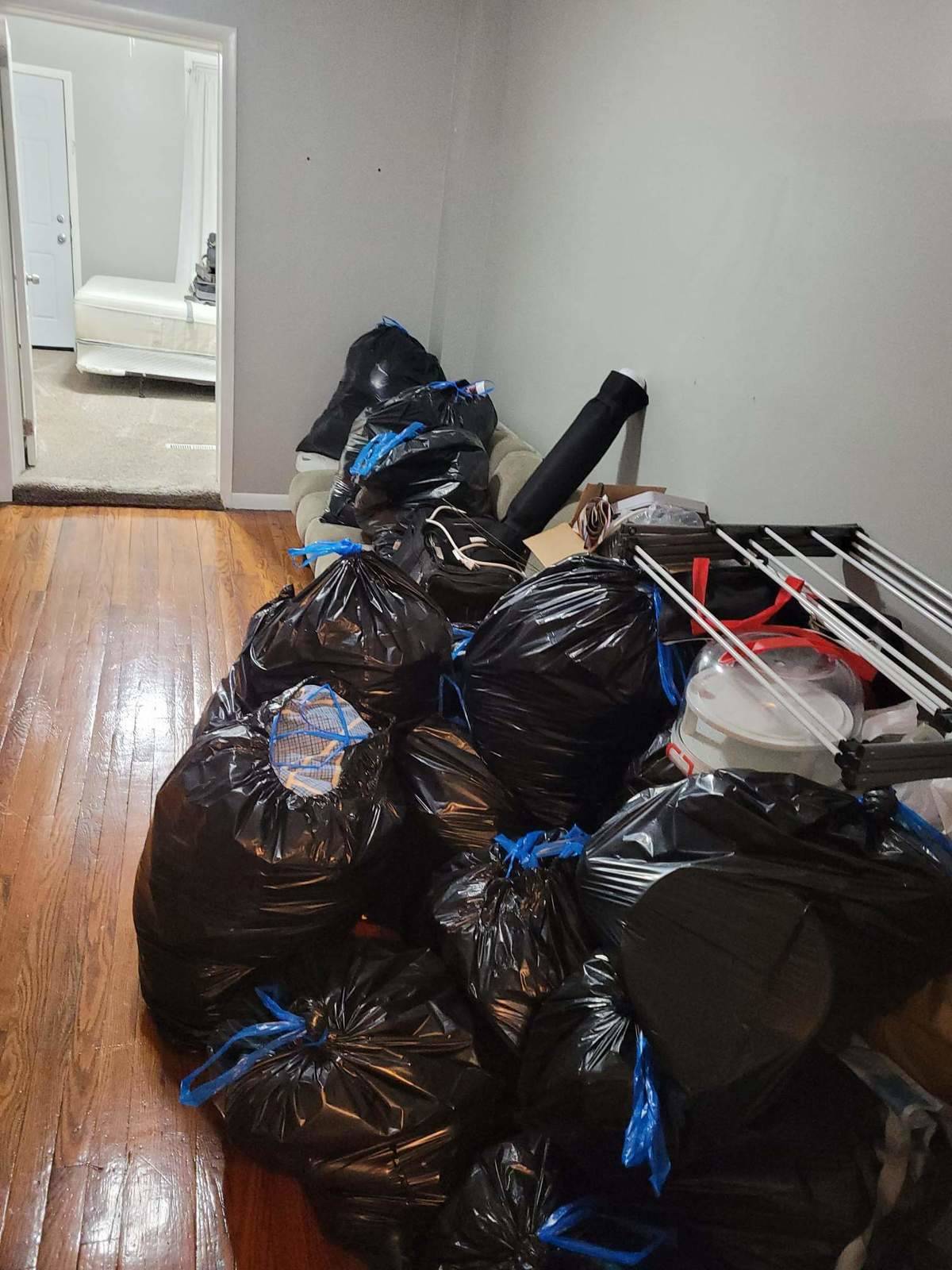 A cleaned out apartment with the tenant's belongings stuffed into several garbage bags.