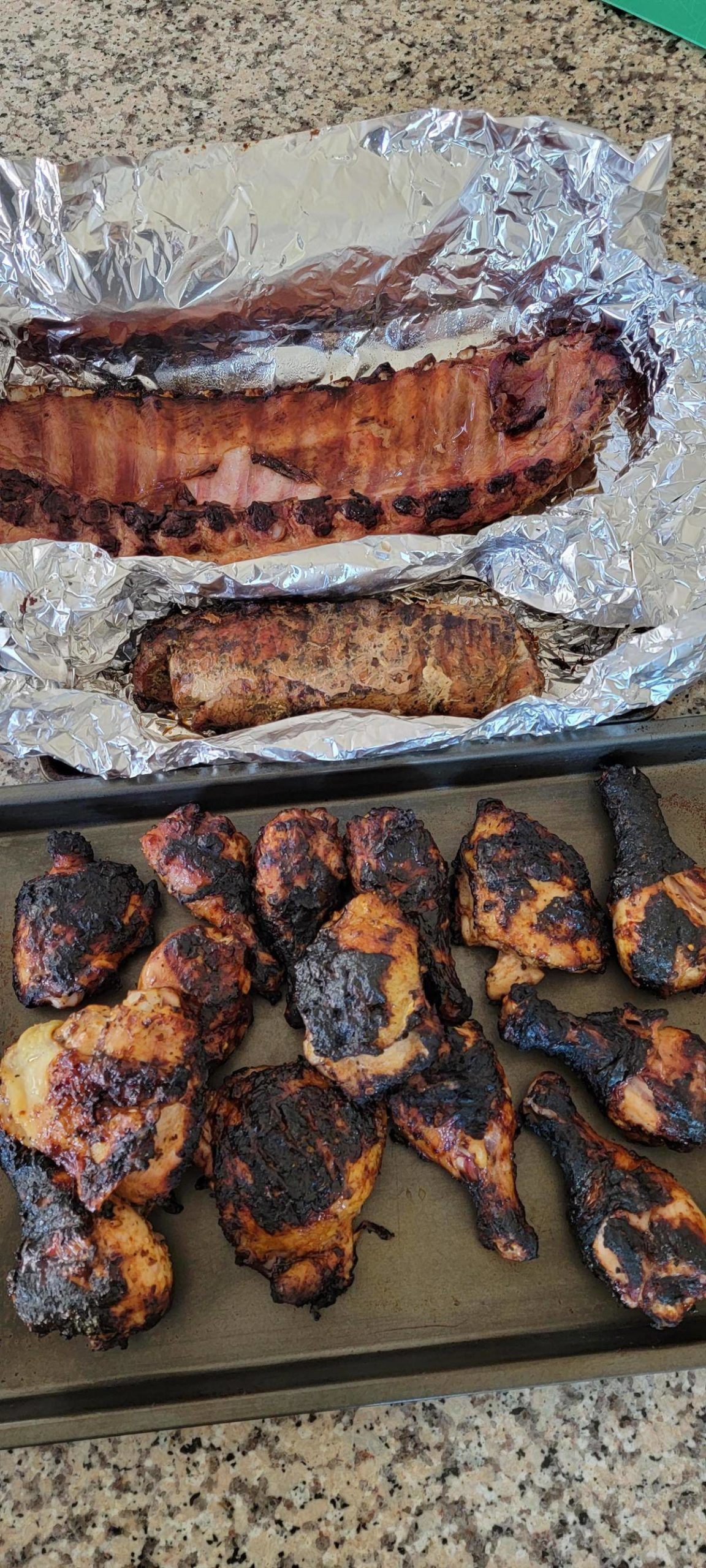 A platter of BBQ food, including ribs and chicken.