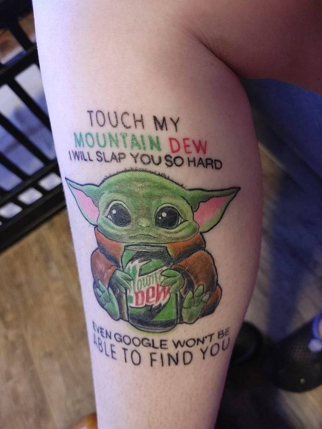 Baby Yoda tattoo holding can of Mountain Dew with text