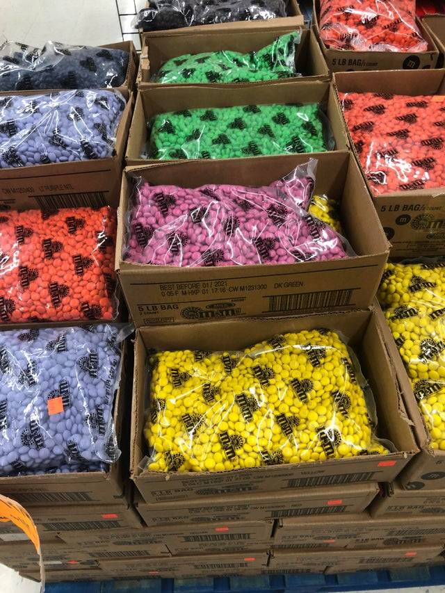 Boxes of bagged individual color M&M's.
