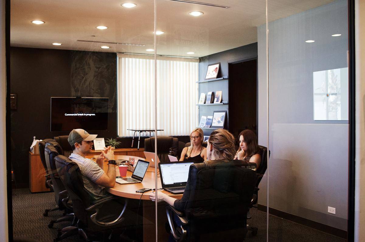 Four people sitting in a conference room. 