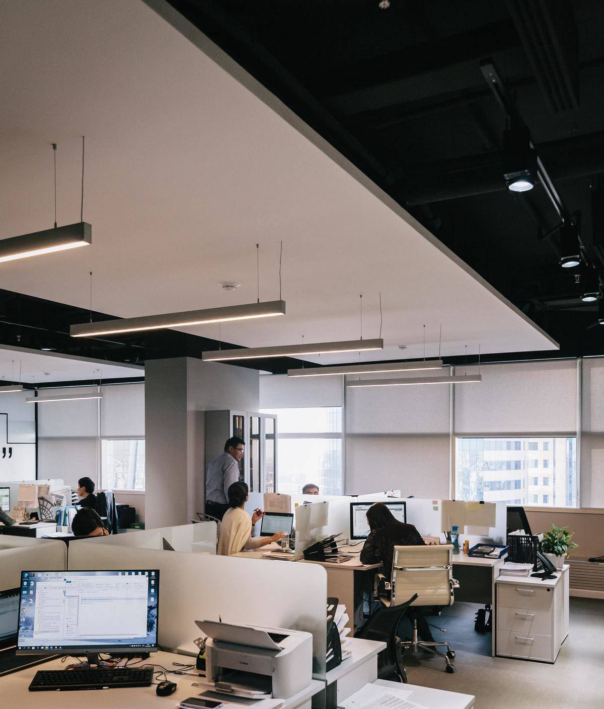 Corporate office with cubicles and people working.