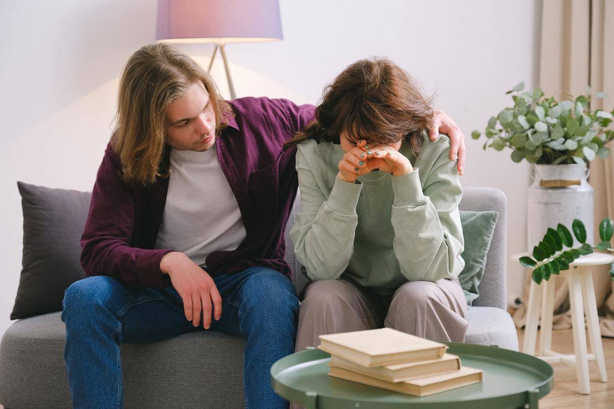 Couple on couch man consoling woman