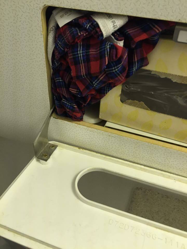 Dirty boxers crammed in with tissue dispenser in airplane bathroom 