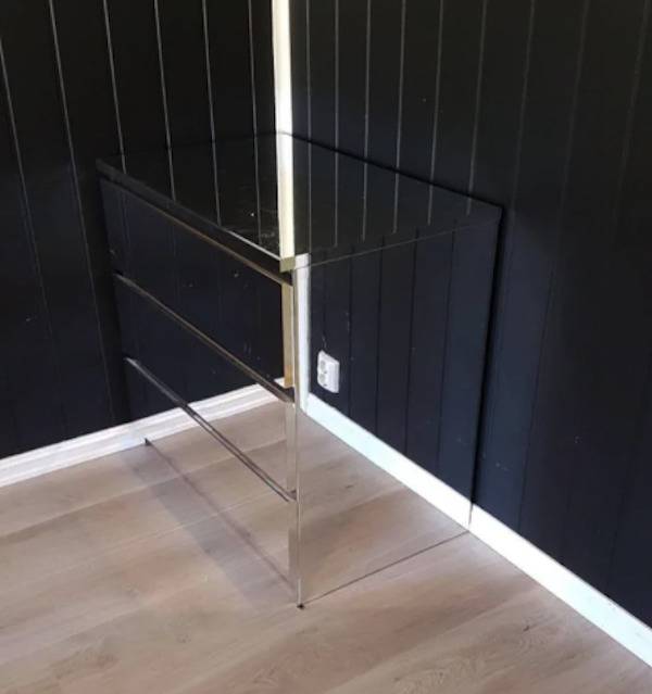 Dresser in the corner of a room and the reflection makes it look invisible