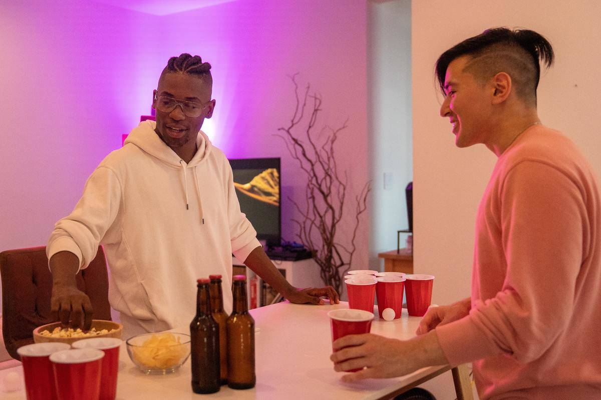 Men playing beer pong at party
