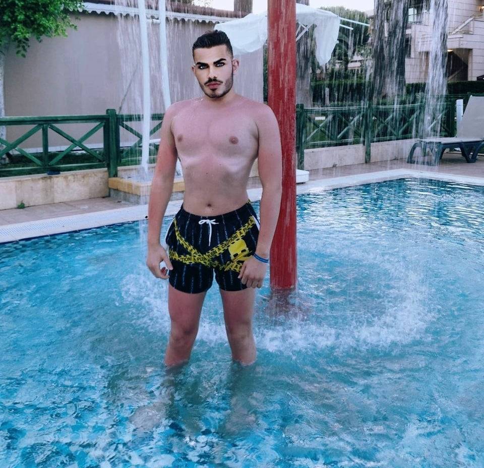 Man standing in a wading pool in a bathing suit. Photo has been heavily edited