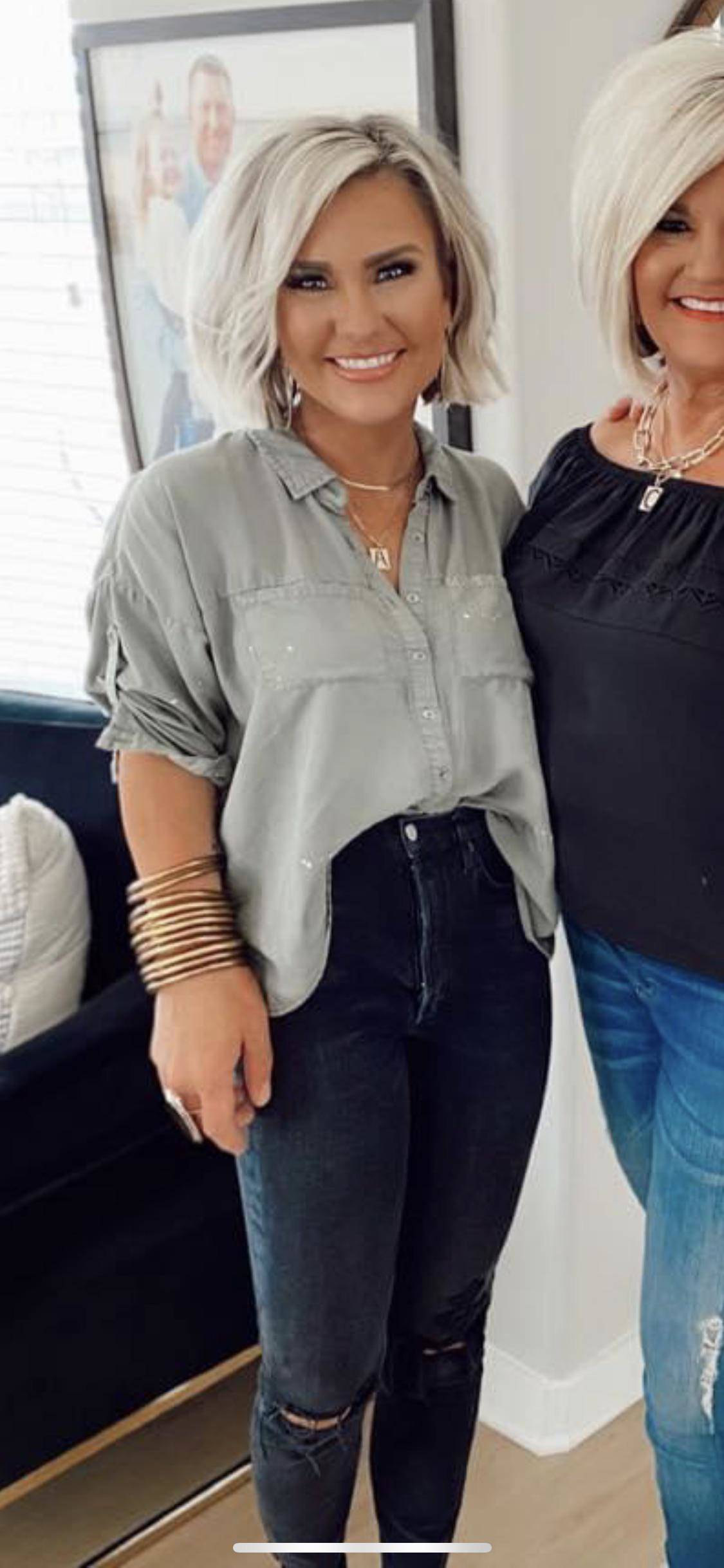 Women with blonde hair wearing grey shirt and black pants has been Photoshopped to have a huge hand