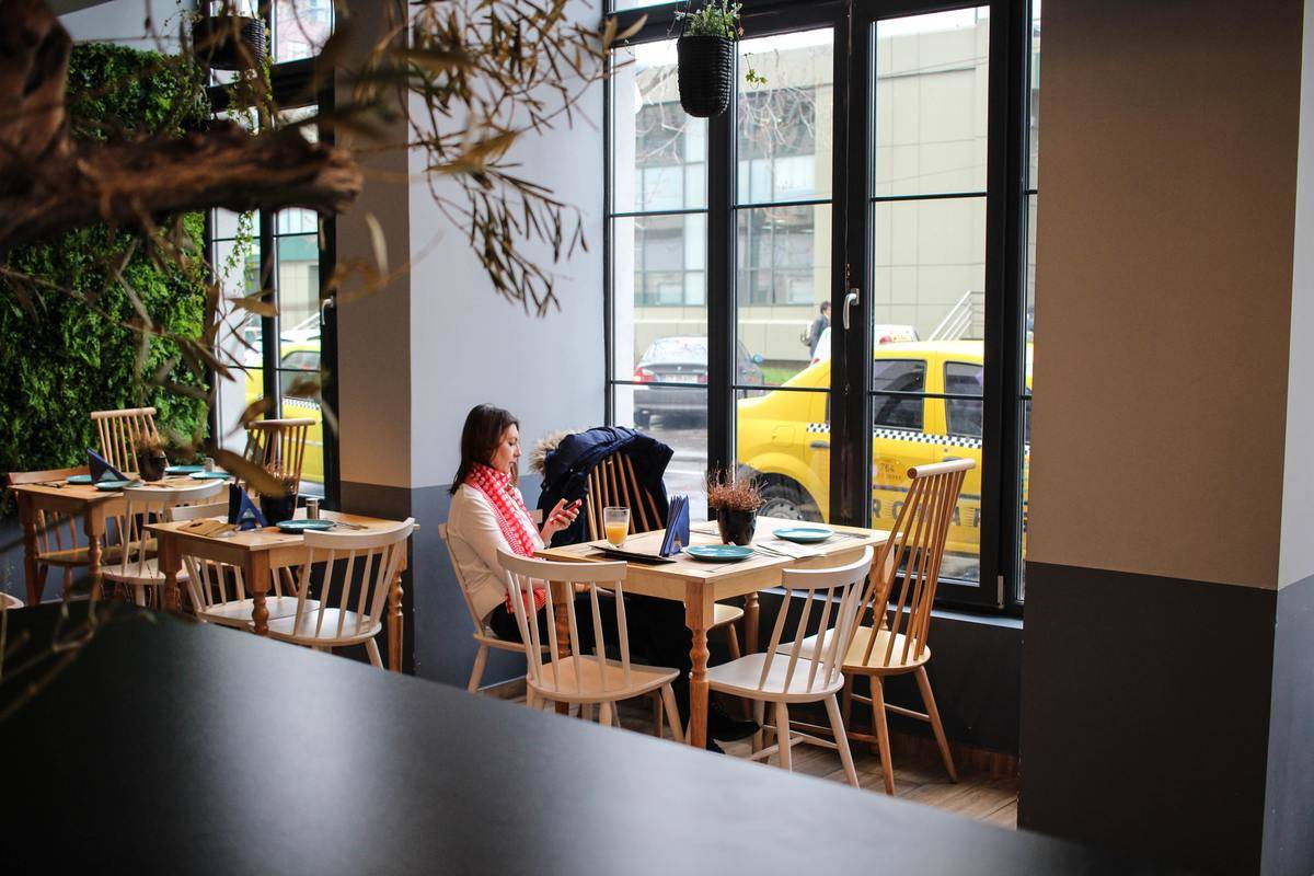 Woman sitting alone at table on phone 