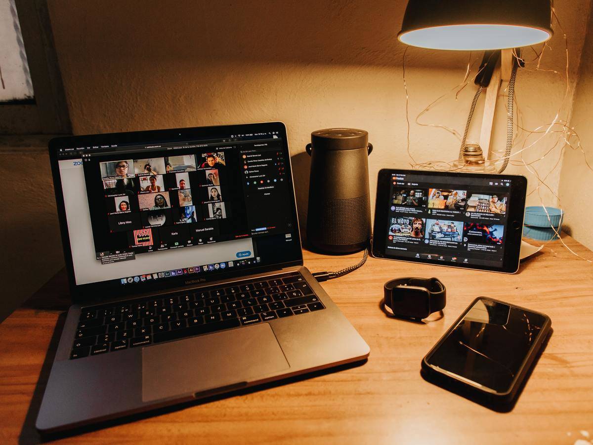 Video call on a laptop with a phone on the desk. 