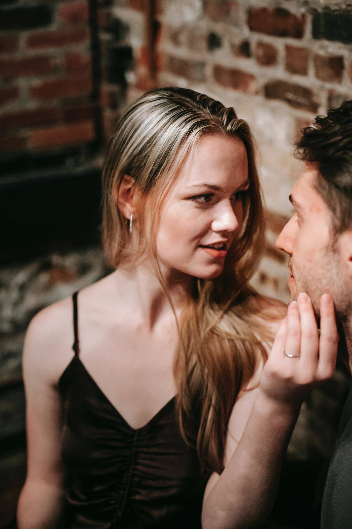 Woman holding man's face looking into his eyes